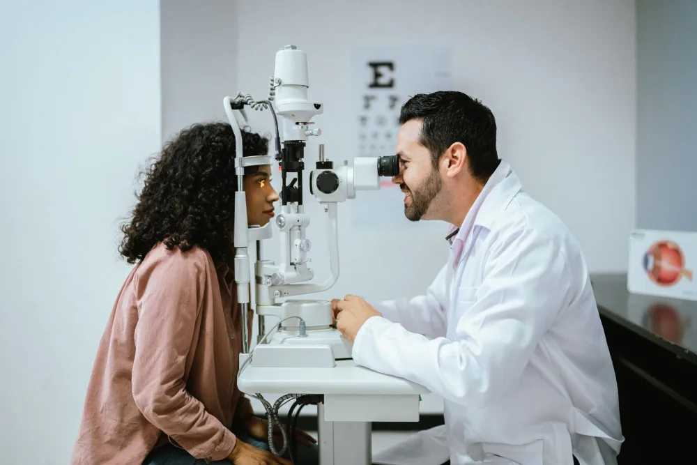 Ophthalmologist performing eye exam using slit lamp at eye care clinic