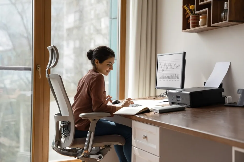 A woman working at a desk and looking at aged accounts receivable information
