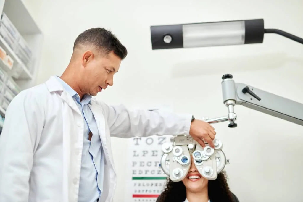 Optometrist adjusting a phoropter during a patient's comprehensive eye examination