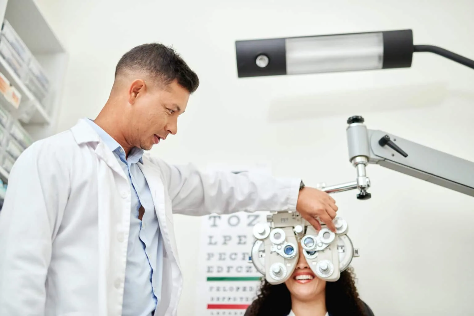 Optometrist adjusting a phoropter during a patient's comprehensive eye examination